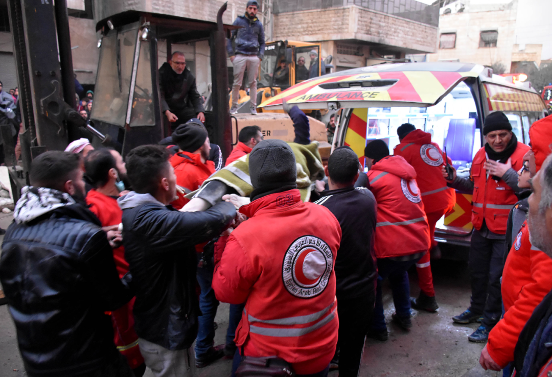 2月6日，人們在敘利亞哈馬省轉運傷者。新華社發