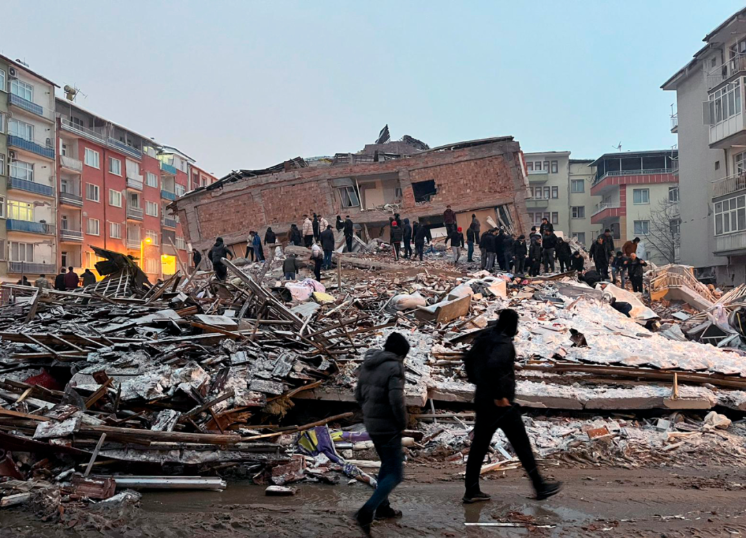 2月6日，人們聚集在土耳其馬拉蒂亞一處倒塌的建築附近。新華社發（穆斯塔法·卡亞攝）