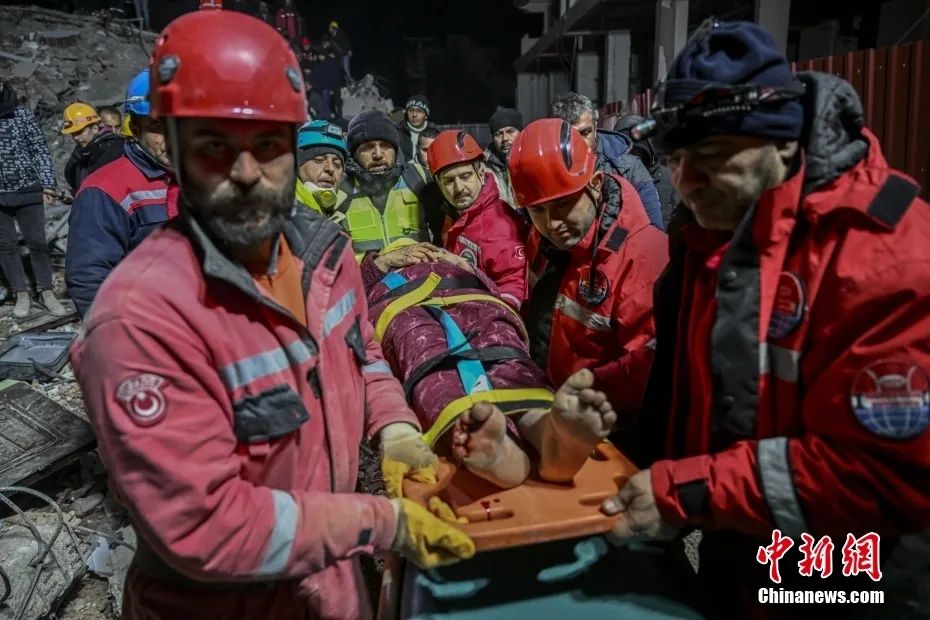 圖為當地時間2月9日，土耳其哈塔伊，一名婦女在倒塌建築物廢墟下被搜救人員救出。圖片來源：視覺中國