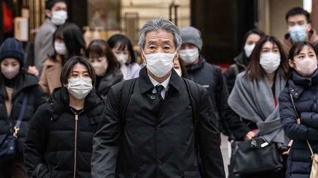 當地時間2023年1月27日，日本東京，人們戴著口罩穿過街道。視覺中國 資料圖
