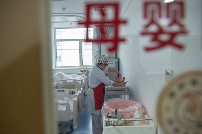 ▲2022年5月10日清晨，产科医生给新生儿称体重。图/新华社