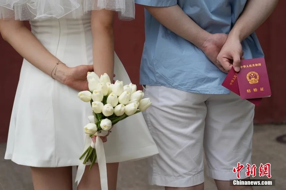 资料图:一对新人在登记结婚后合影留念。中新社记者 崔楠 摄