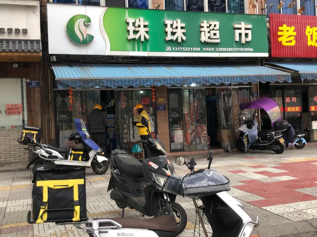 浙江安吉县的一家夫妻小店门前,外卖配送小哥正等待取货。摄影:郭瑞