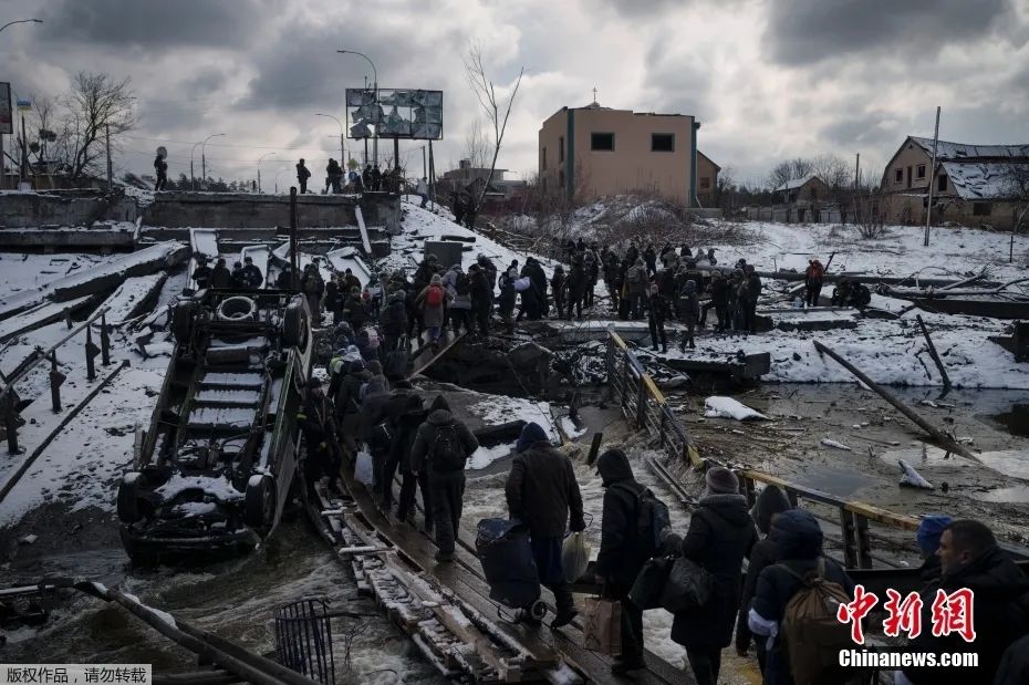 圖為當地時間2022年3月8日，烏克蘭基輔郊區，當地民眾撤離伊爾平時，穿過一條在廢墟上臨時搭建的道路。