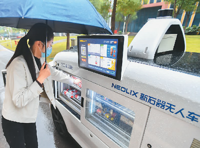 在湖南省检验检测特色产业园内,市民通过无人零售车购买商品。新华社记者 陈泽国摄
