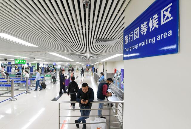 3月15日,旅客在深圳罗湖口岸入境检查大厅准备入境。新华社记者毛思倩 摄