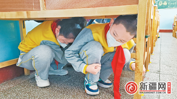 3月27日上午，市第3小学进行地震演练，学生迅速躲在书桌底下避险。（全媒体记者刘薇摄）