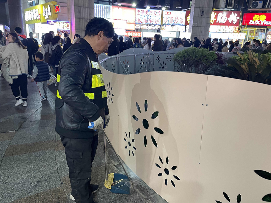 保洁员在花园处打扫卫生。