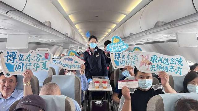 图为东航乘务员与机舱内乘客合影。中国东航供图