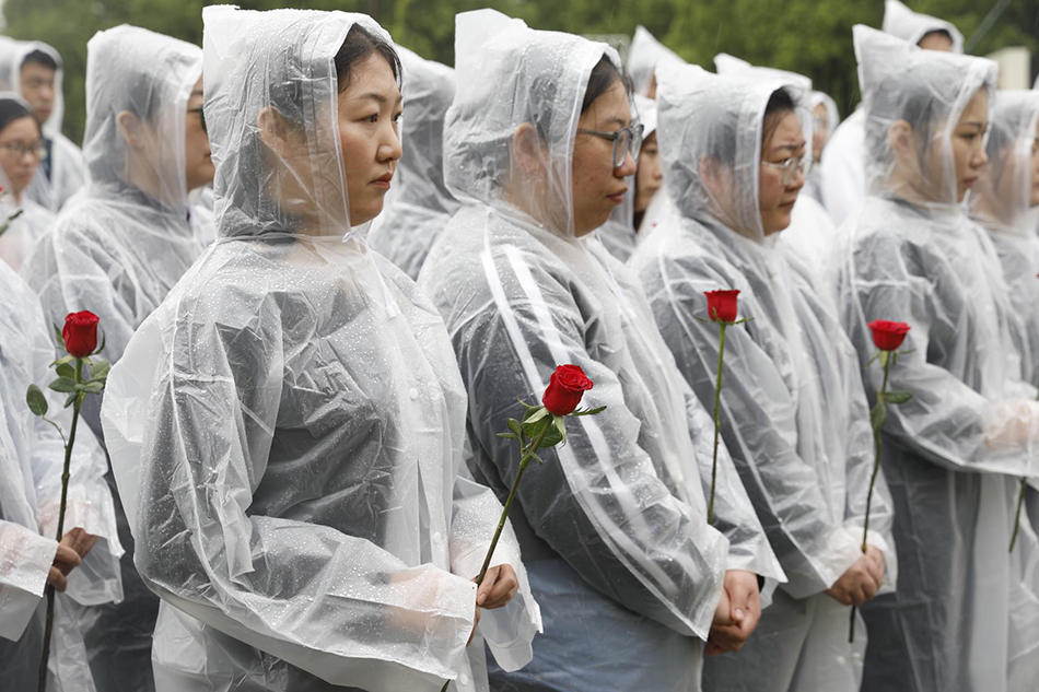 吳孟超院士逝世2週年悼念祭掃，人們依次敬獻手中鮮花。