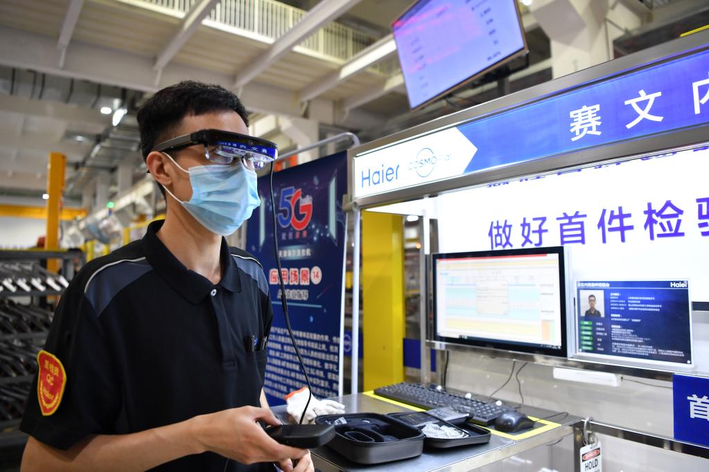 在天津海爾洗衣機互聯工廠內,工作人員利用5G技術進行檢驗工作。新華社記者 李然 攝