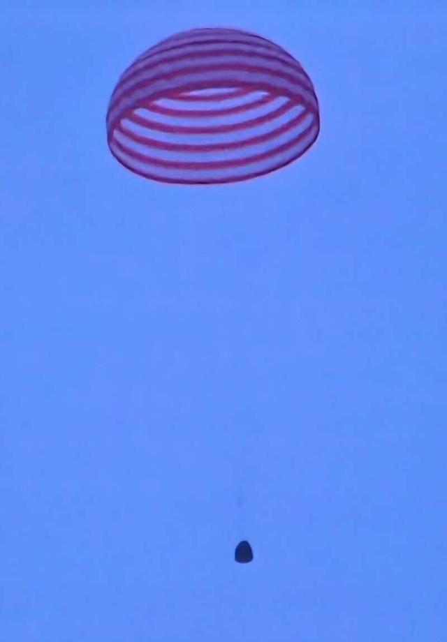 神舟十五號載人飛船返回艙大傘綻放光學影像。張珂森翻拍/酒泉衛星發射中心供圖