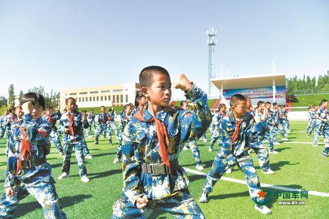 内蒙古鄂尔多斯市鄂托克前旗海军希望小学少年军校的同学在练习军体拳、观看装备模型。蒋世伟、杨建荣摄