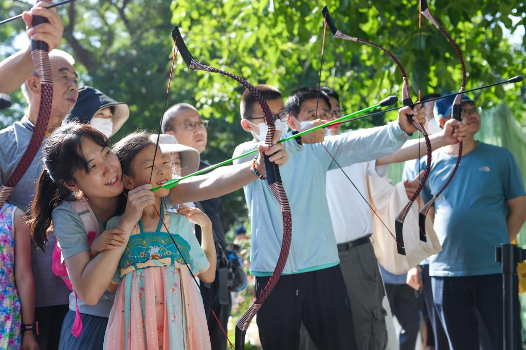 6月22日，小朋友和家長一起在北京龍潭公園體驗射五毒。新華社記者鞠煥宗攝