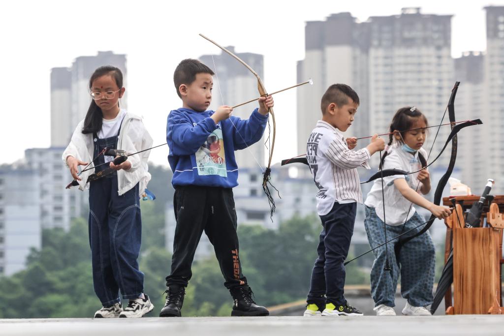 2022年6月3日，在貴州省貴陽孔學堂舉行的端午活動上，幾名小朋友在體驗「射五毒」。新華社記者歐東衢攝