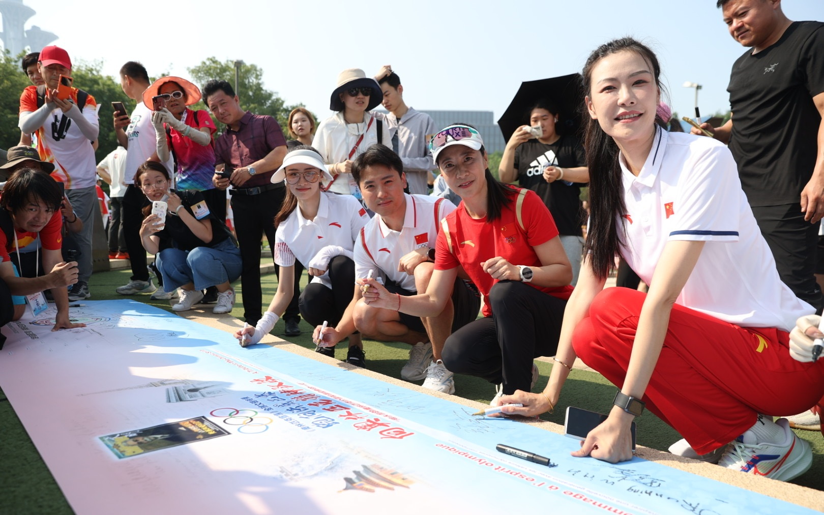 王麗萍和運動員嘉賓在橫幅上籤名。新京報記者 王飛 攝