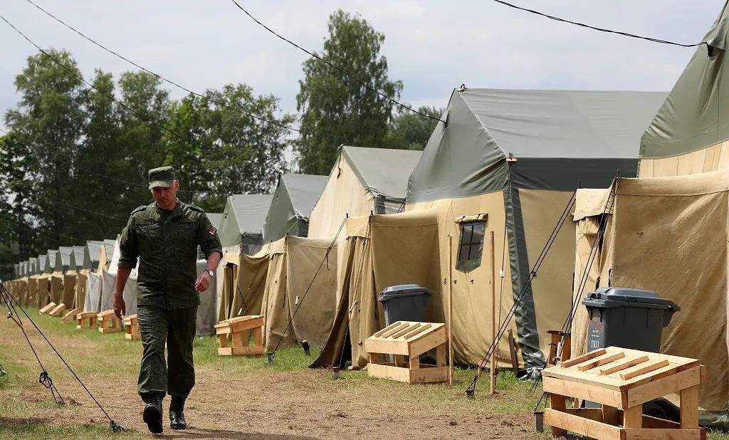 當地時間2023年7月7日，白俄羅斯阿西波維奇，一名白俄羅斯士兵走過新建的營地，目前可能容納多達5000名瓦格納人員。