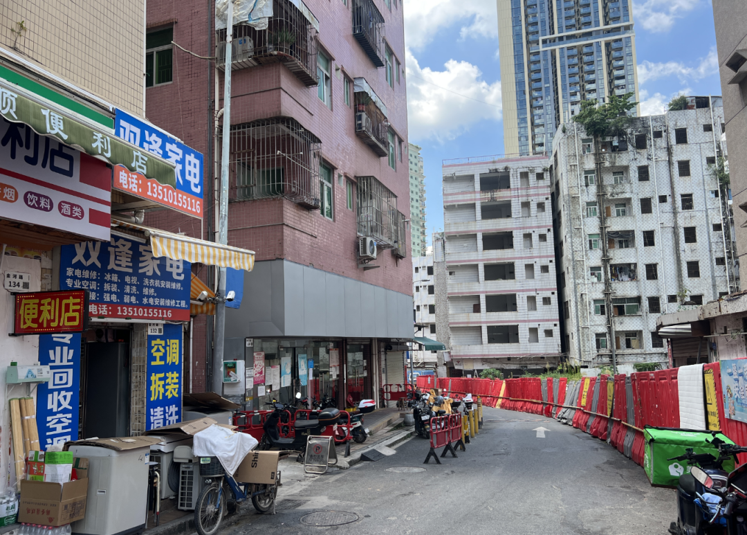 (红色挡板把拆迁中的白石洲分割成待遇不同的世界)