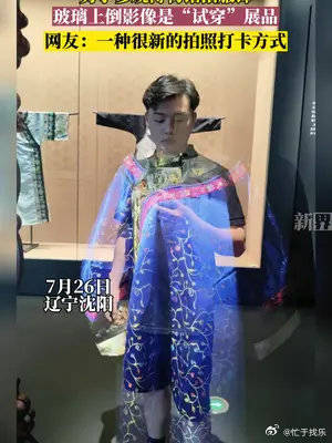 男子参观博物馆拍服饰，玻璃上倒影像是“试穿”展品