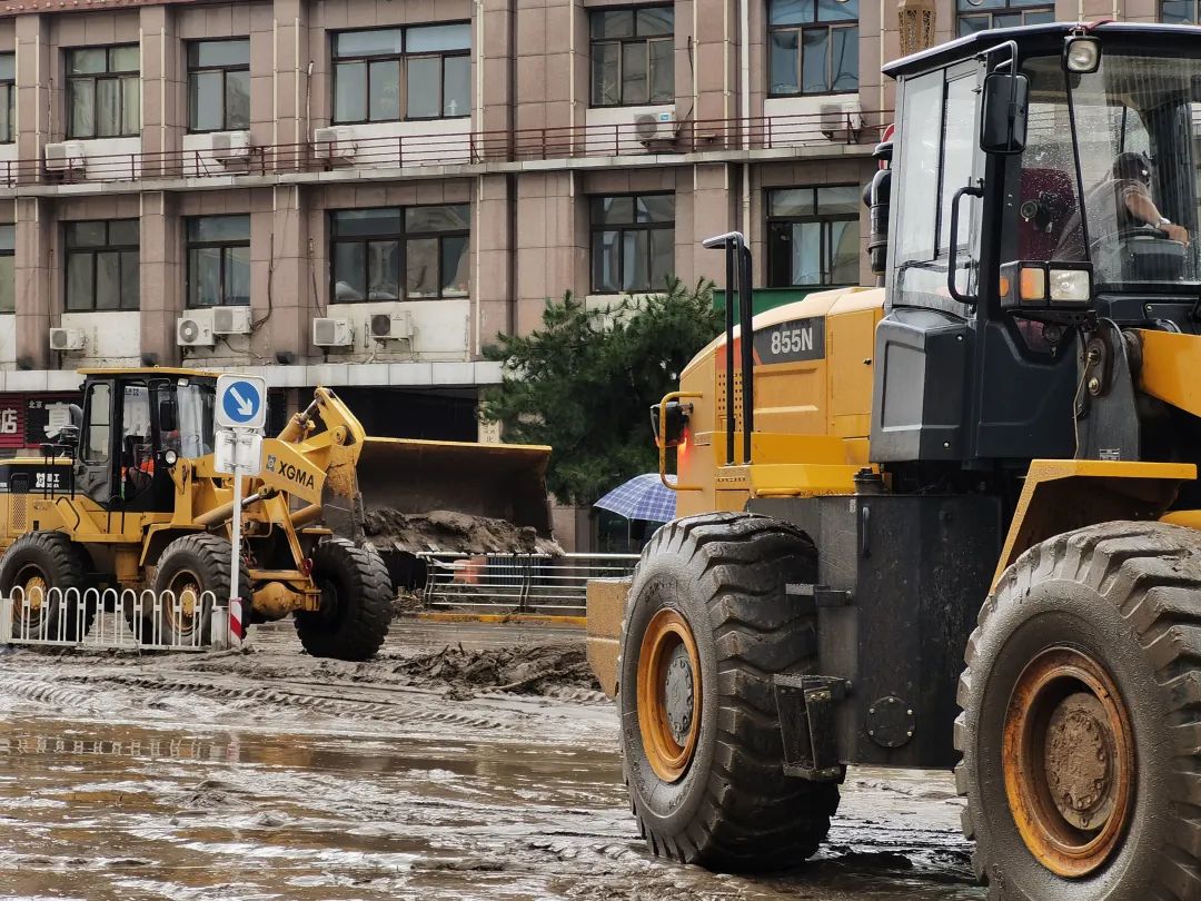 ▲铲车正在清理道路上的淤泥。新京报记者 裴剑飞 摄