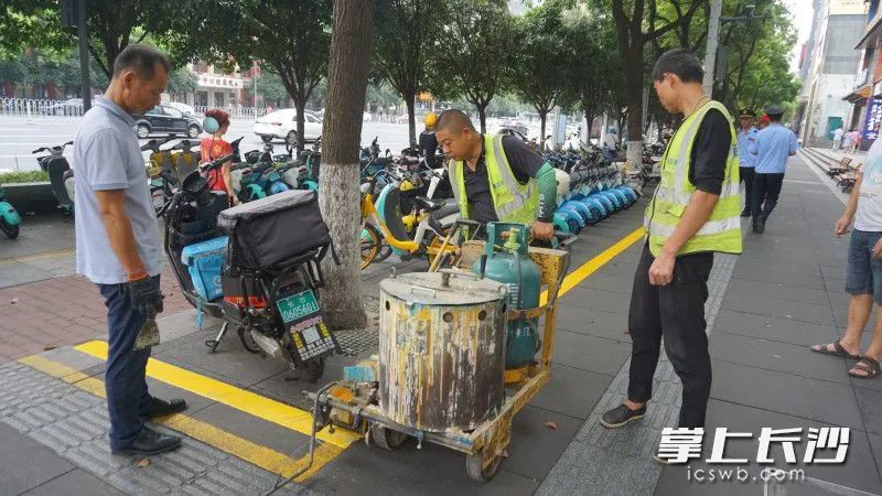 施工人员正重新施划非机动车停车位。