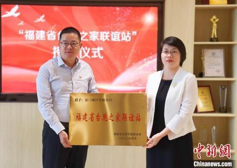福建省台联副会长欧阳迪莎(右)授予厦门银行宁德分行“福建省台胞之家联谊站”牌匾。吴允杰摄