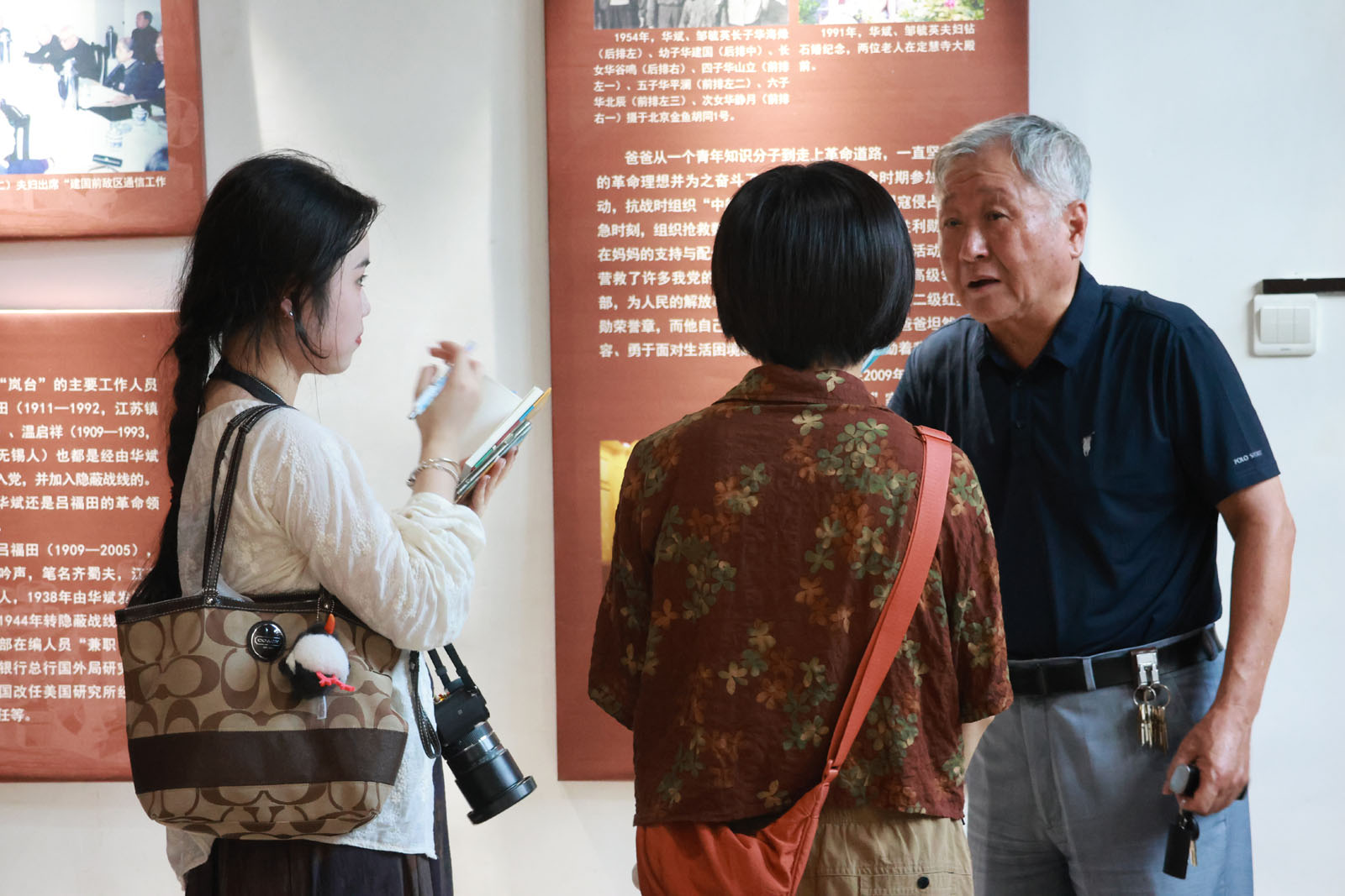 图为华金生(右一)向记者讲述华氏家族故事