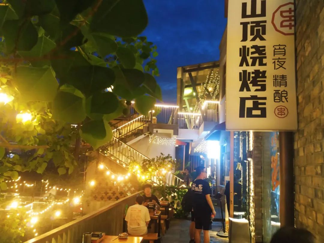 △往昙华林山上走,灯光闪烁,音乐飘荡,就着灯光品尝美食,十分浪漫。记者程佳怡摄