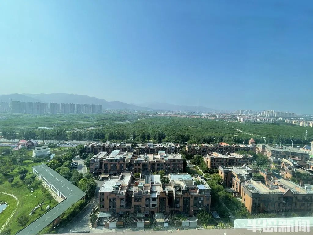 衣建梅居住的小区,从阳台上向南望去是一大片桃园。(受访者供图)