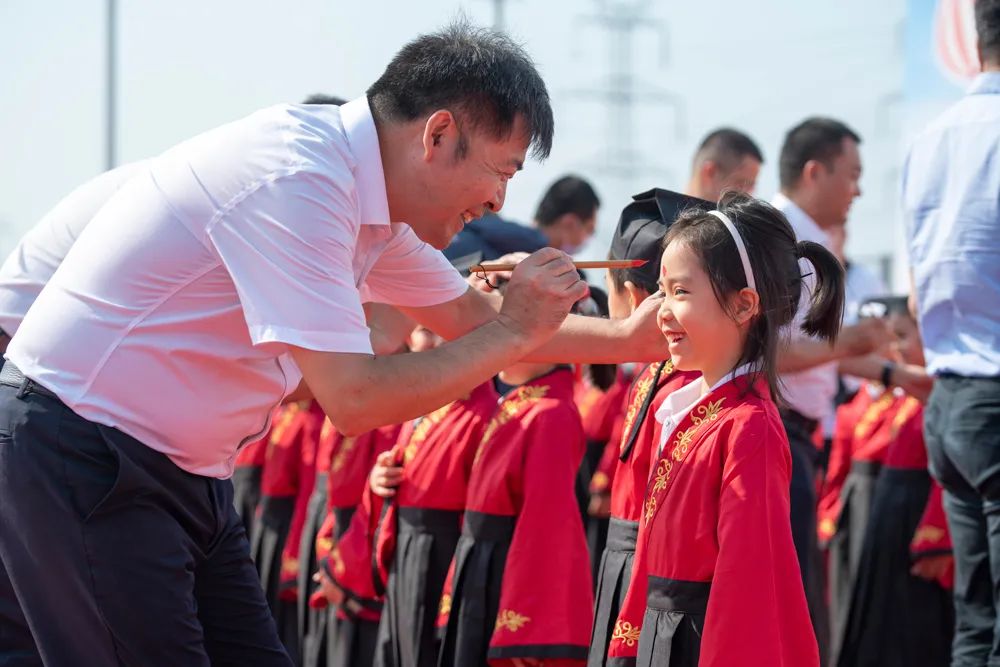 在入学开笔礼上,王教凯为一年级新生点朱砂启智。图片由学校提供