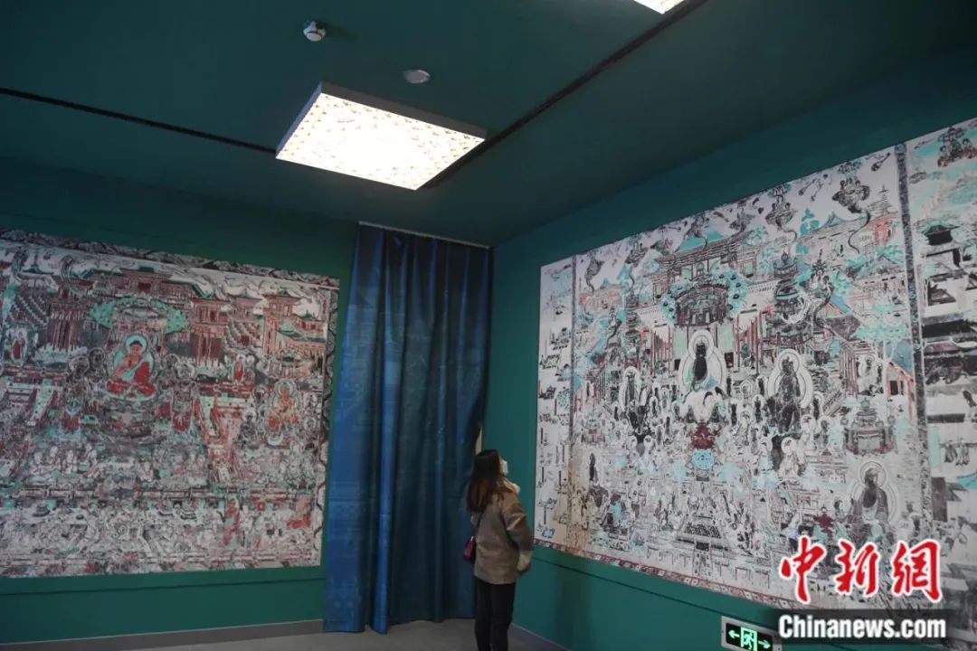 参观者在位于甘肃兰州的敦煌艺术馆观赏复制的高保真莫高窟壁画。杨艳敏 摄