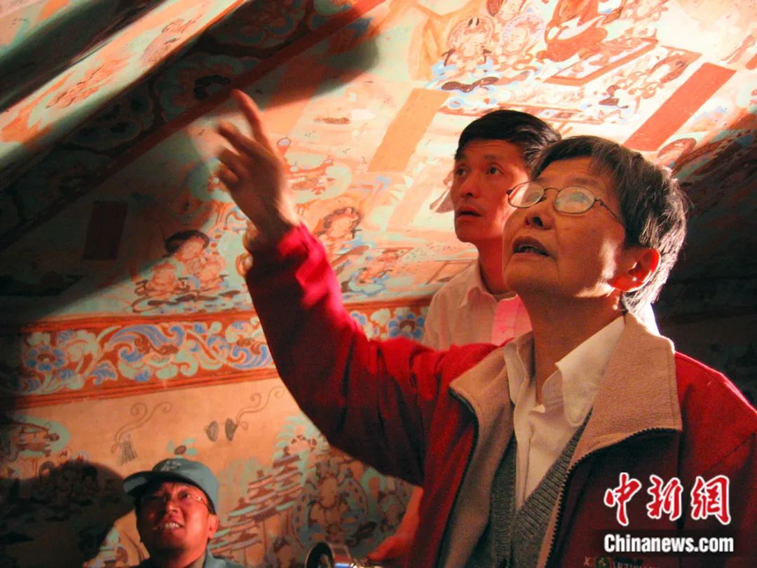樊锦诗（右一）在莫高窟第85窟壁画修复现场。敦煌研究院供图