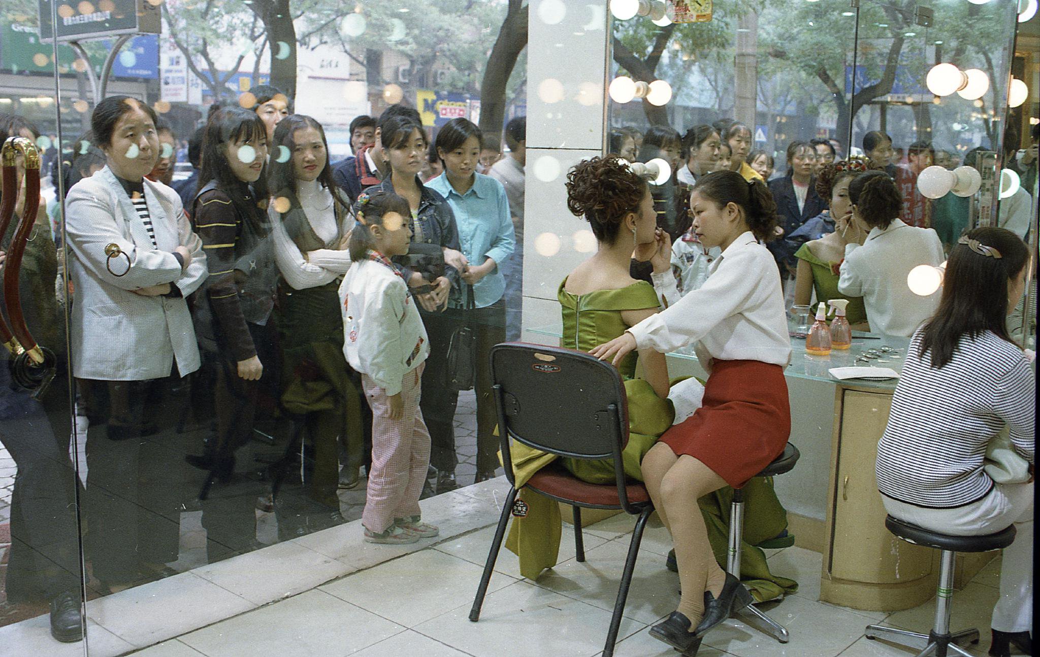 西安东大街上隔着玻璃窗看化妆的女人们,1998年10月