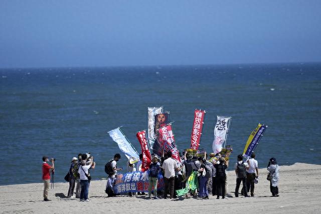 當地時間2023年8月24日，日本浪江町，人們在海灘上抗議的大地震和海嘯中受損的福島第一核電站。視覺中國 圖