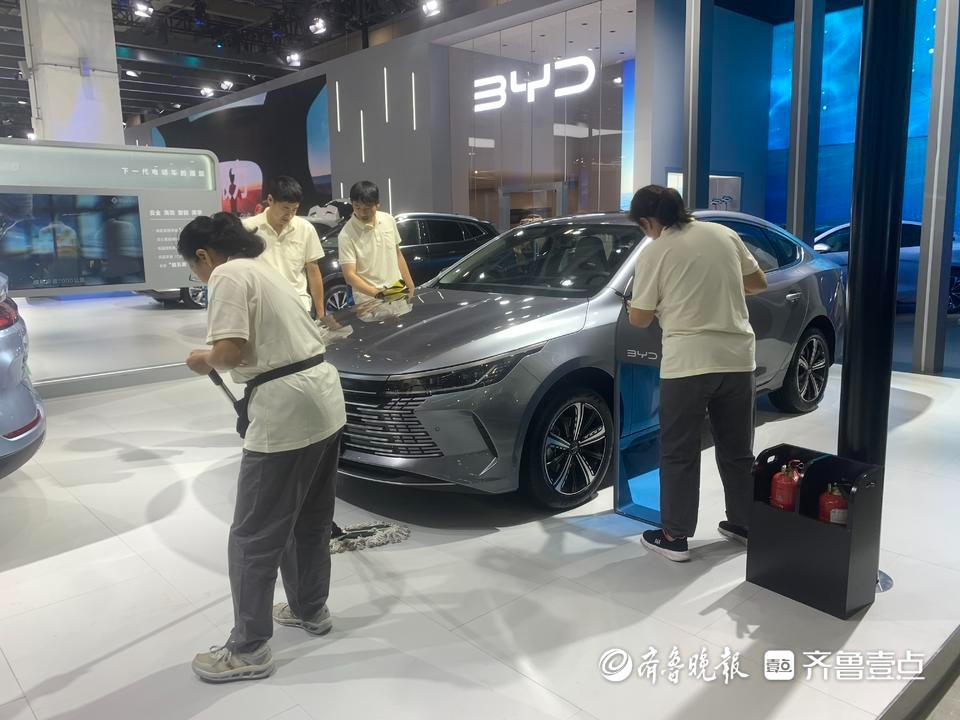 齐鲁国际车展周六开馆在即，工作人员清洁车辆等待观众