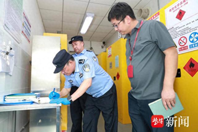图为南京市公安局江北新区分局治安支队民警对辖区企业危化品存储情况进行检查