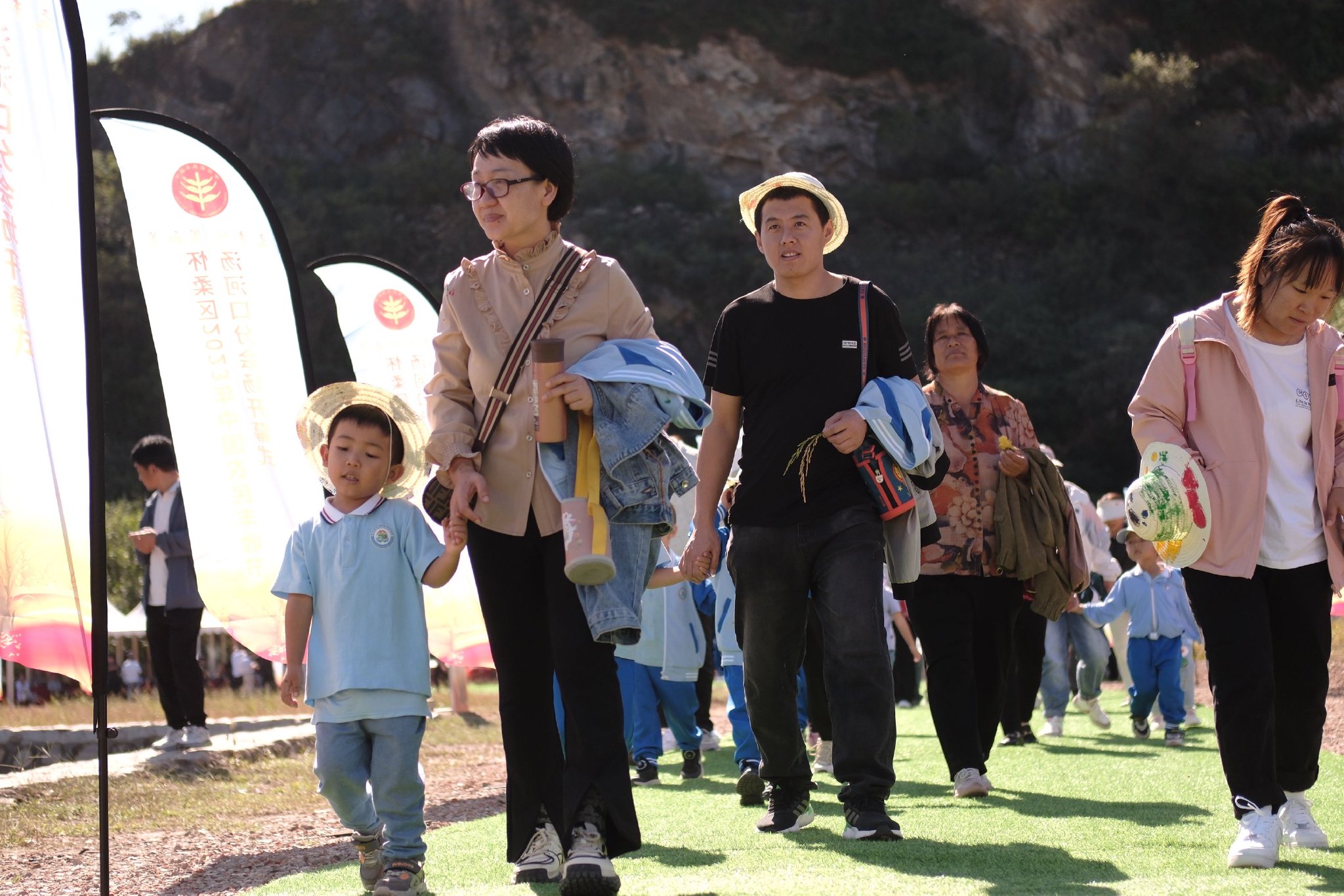 9月20日,湯河口鎮豐收節開幕禮現場,市民頭戴草帽參加。新京報記者 曹晶瑞 攝