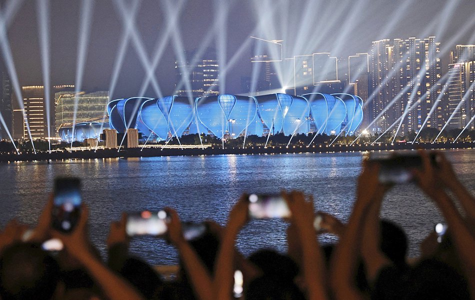 2023年9月18日晚,杭州亞運會開幕式演練在浙江杭州奧體中心舉行,璀璨燈光秀點亮夜空,市民打卡拍照。
