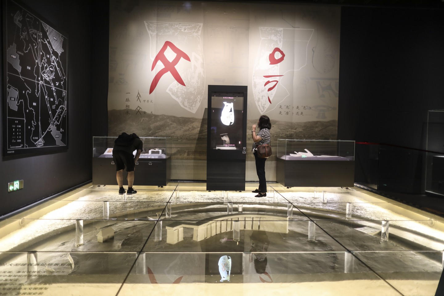 9月21日,觀眾在觀看山西襄汾陶寺遺址出土的文物,底下是陶寺城址大型建築基址場景複原。新京報記者 浦峰 攝