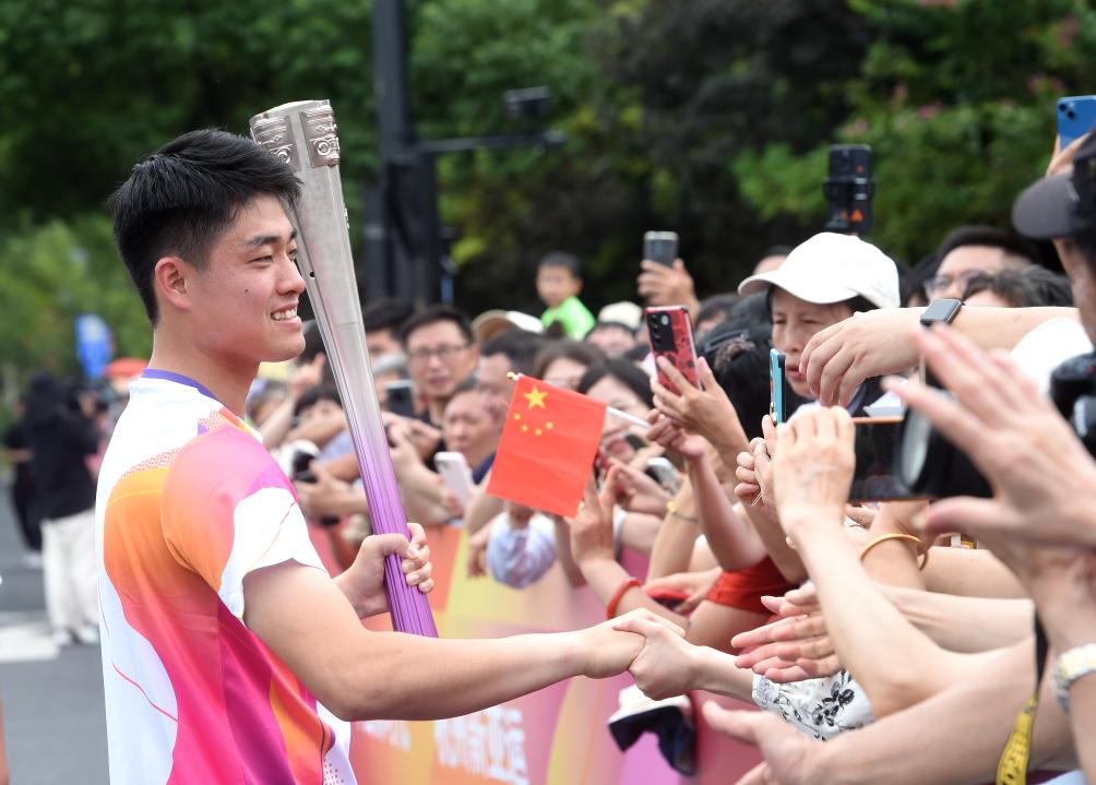 9月20日，火炬手吳易昺（左）在火炬傳遞前與觀眾互動。新華社記者 韓傳號 攝