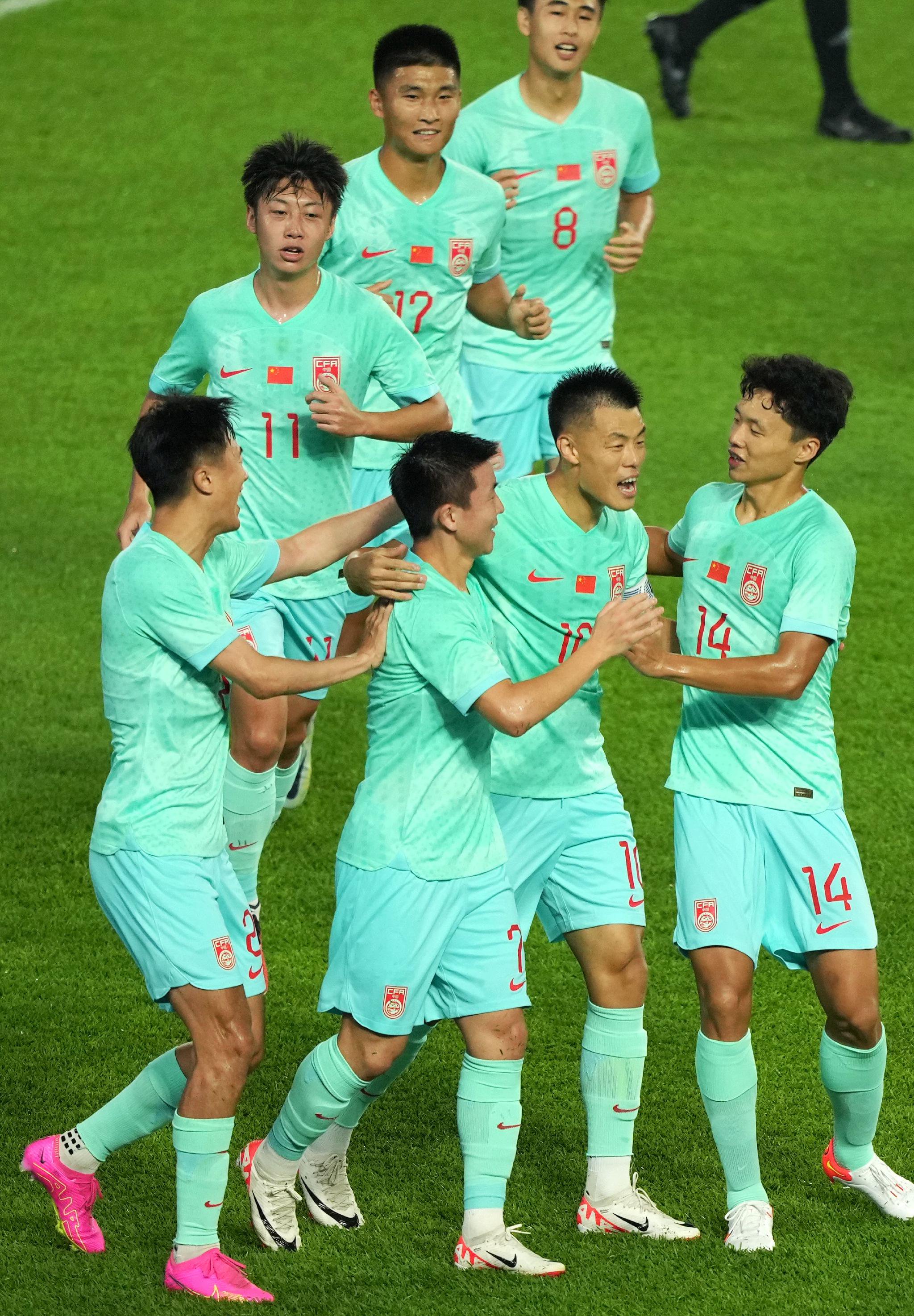 小夥子們慶祝入球,中國隊憑藉兩場勝利提前出線。 圖/新華社
