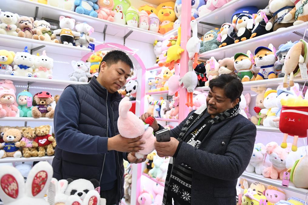 來自印度的客商(右)在義烏國際商貿城的一家玩具店舖內選購(2月2日攝)。新華社記者 黃宗治 攝