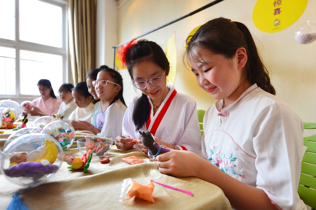 9月27日,在山东省青岛市市北区杭州路小学民俗迎中秋活动上,学生们在用太空泥制作嫦娥。王海滨 摄