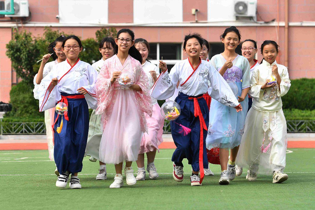 9月27日,在山东省青岛市市北区杭州路小学民俗迎中秋活动上,学生们在操场上体验制作好的月亮花灯。王海滨 摄