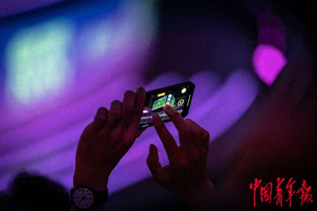 9月28日上午,杭州电竞中心,一名记者拍摄现场大屏幕上的比赛画面。中青报·中青网记者 李隽辉/摄