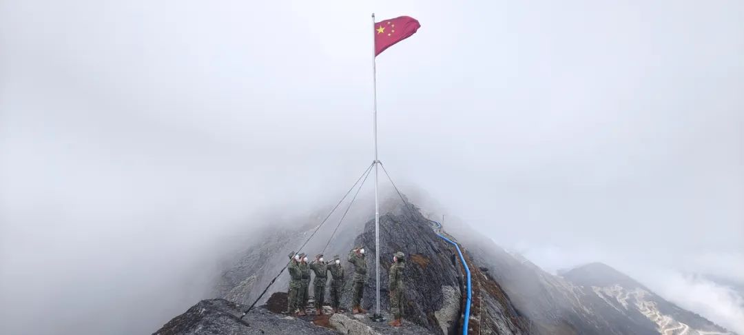 西藏亚东海拔4655米的詹娘舍哨所官兵在哨所旁的崖壁上举行升旗仪式。