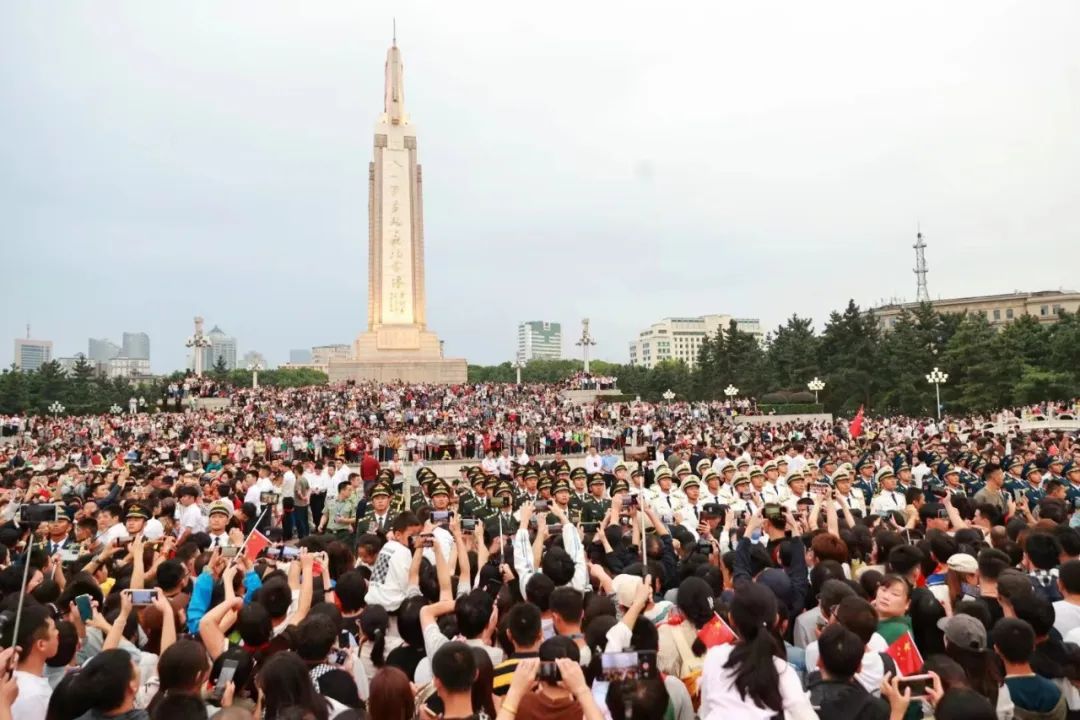 游客在八一广场等候观看升旗仪式。