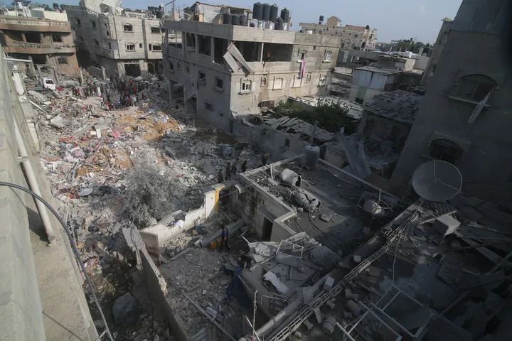 10月8日，在加沙地帶南部城市拉法，人們查看被以色列空襲炸燬的建築。新華社發（哈立德·奧馬爾攝）