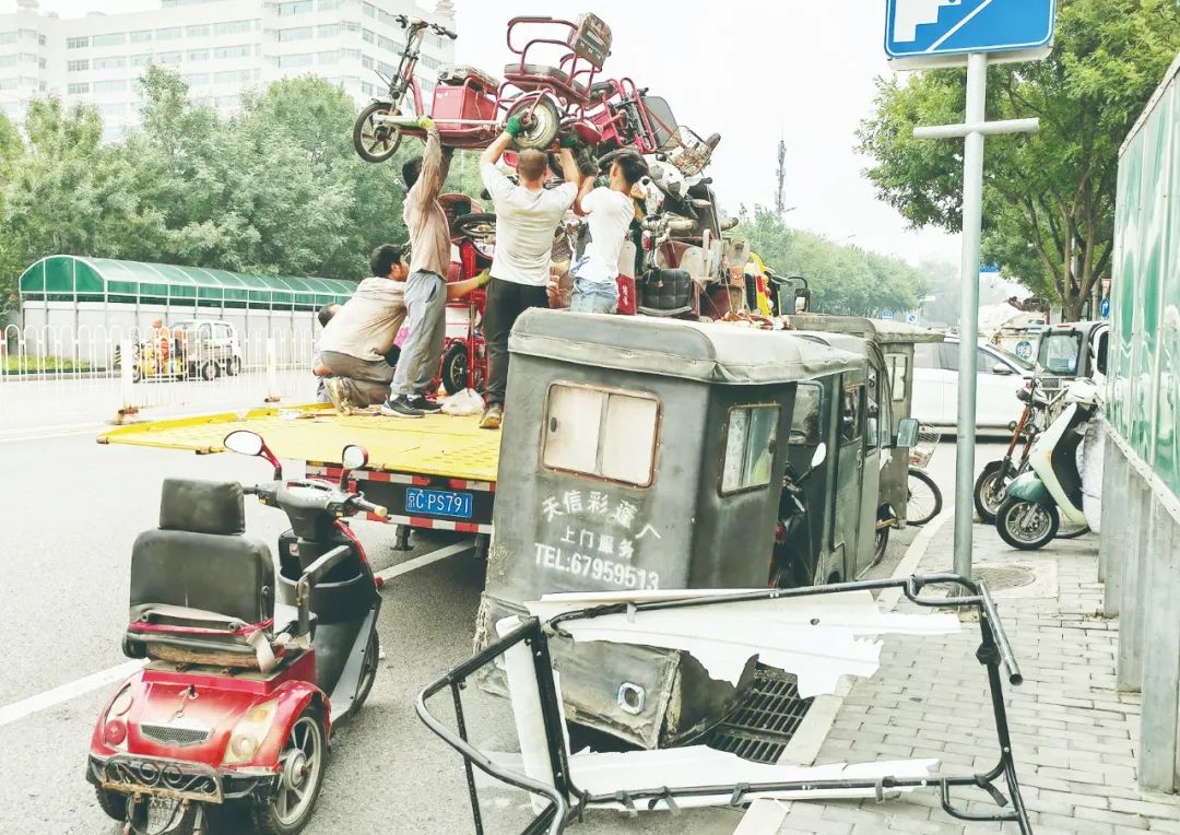 ▲图为在北京西城区的北手社区违规电动车收集站,废品回收人员正在将市民送交来的电动车装车运往废品站。视觉中国