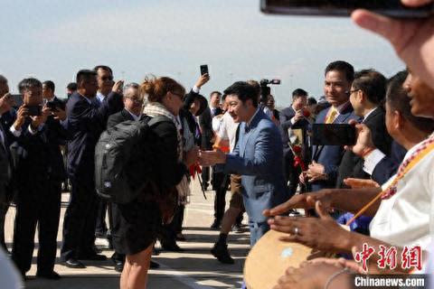 10月16日,柬埔寨暹粒吴哥国际机场通航运营。图为柬埔寨旅游部大臣宋速更为游客送上鲜花及祝福。(黎海月 摄)
